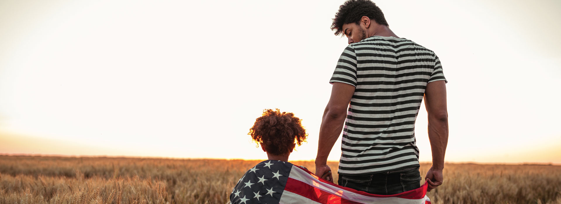 Man and child wrapped in USA flag